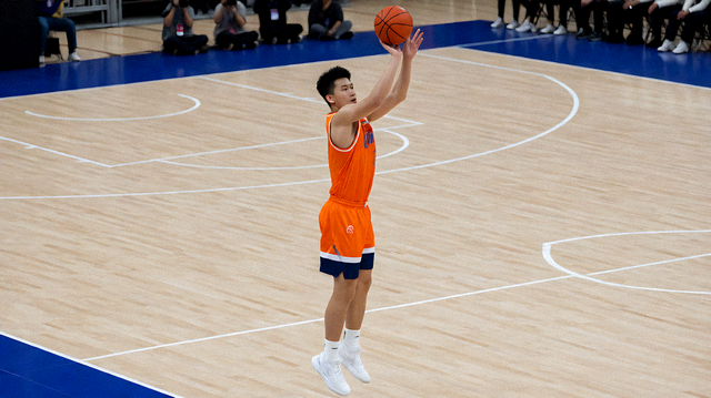 篮球比赛中球员在三分线外出手投篮的赛场画面